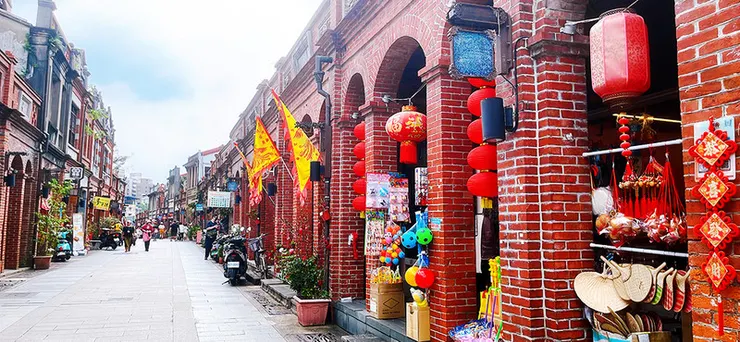 台北旅遊景點三峽老街傳統紅磚建築街景，街道掛滿紅色燈籠與飄揚旗幟，展現濃厚懷舊氛圍與在地文化特色。