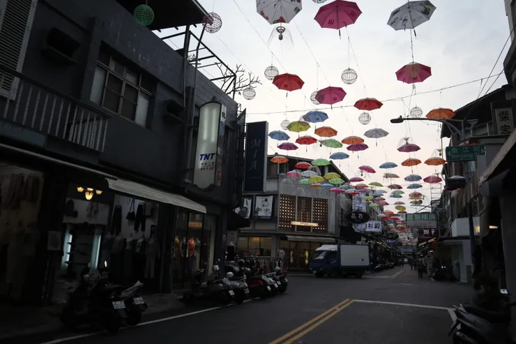 華燈初上,店面室內燈從建築外觀的孔隙中微微發亮