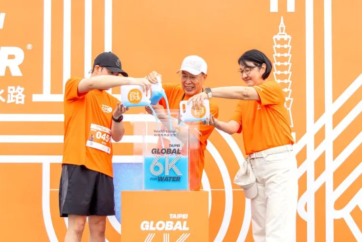 ▲台灣世界展望會董事長林啓峰(中)、會長李紹齡(右)、領跑人亞瑟(左),共同將希望之水倒入象徵匯集愛心的水桶中,一起為孩子而跑。(台灣世界展望會提供)