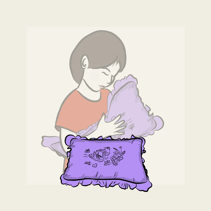 一個女孩手抱著阿媽和姑姑縫製的鴛鴦繡花枕頭。