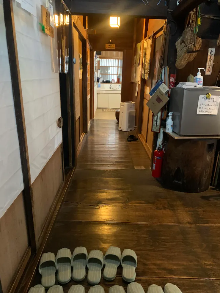 排列整齊的拖鞋以及亮得反光的木地板