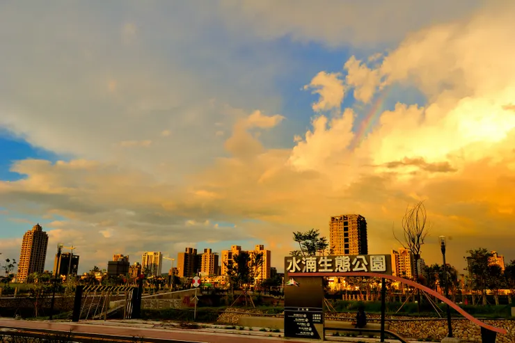 【落日回收灼人熱氣燒紅了西天，東邊的雲也反映了色彩，此時又可見一小段彩虹。】