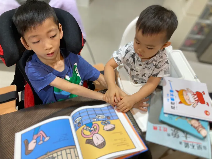 閱讀從零開始，健康手足幫身障手足翻書一起共讀。