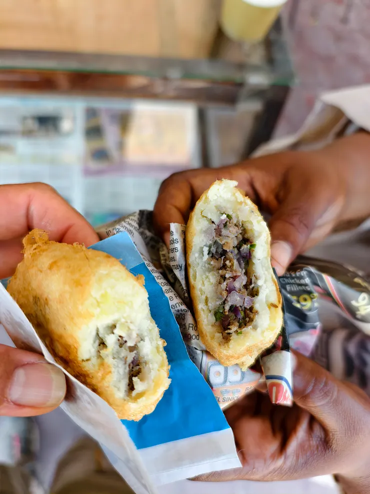 油炸馬鈴薯餡餅，我的是包雞肉，Samira 的是包牛肉。剛出爐的餡餅裝在兩個大塑膠袋中，拿出來用報紙包給我們。我咬了一口，很好吃，只是......