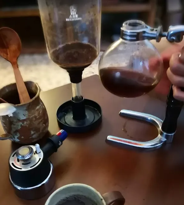 虹吸登場：下壺裝水加熱，水沸騰後順著玻璃管往上湧，與上壺的咖啡粉相遇；透過加熱與冷卻的壓力變化