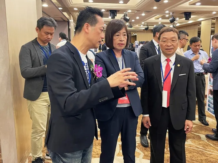 圖說：亞家生技創辦人吳坤烈博士（前排左）於展場攤位，向國發會副主委高仙桂（前排中）解說介紹「微型智能細胞製劑廠」。（資料來源：亞家生技）