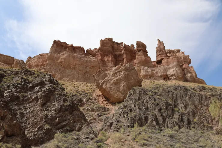 在黑色變質岩與紅橙沉積岩之間，有一顆孤石