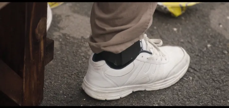 李強勳父親李才滿的電子腳鐐讓李強勳不想面對，總是延遲回家的時間。( Source : Disney + )