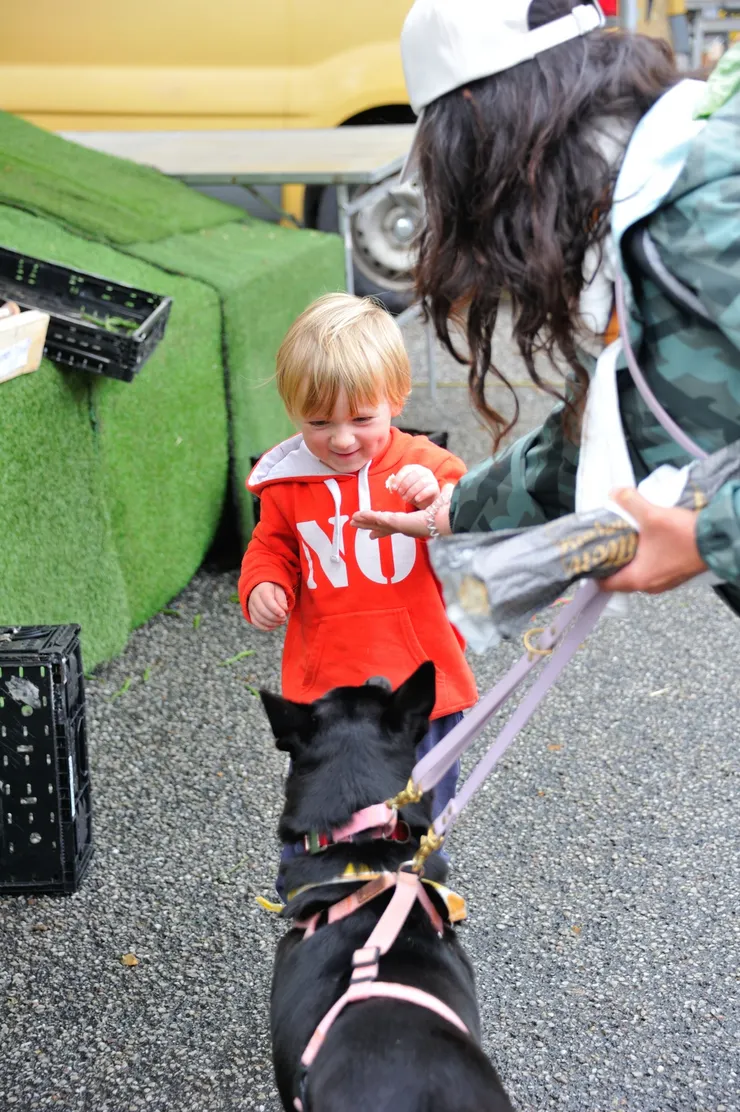 【附近空地恰有小農市集，又去採購了些蔬果！怡青拿狗食給菜販可愛的小兒子餵阿肥。】