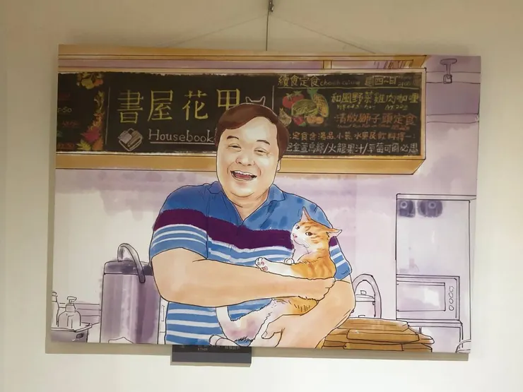 一進店內就可以看到方里長抱著店貓花甲的畫作