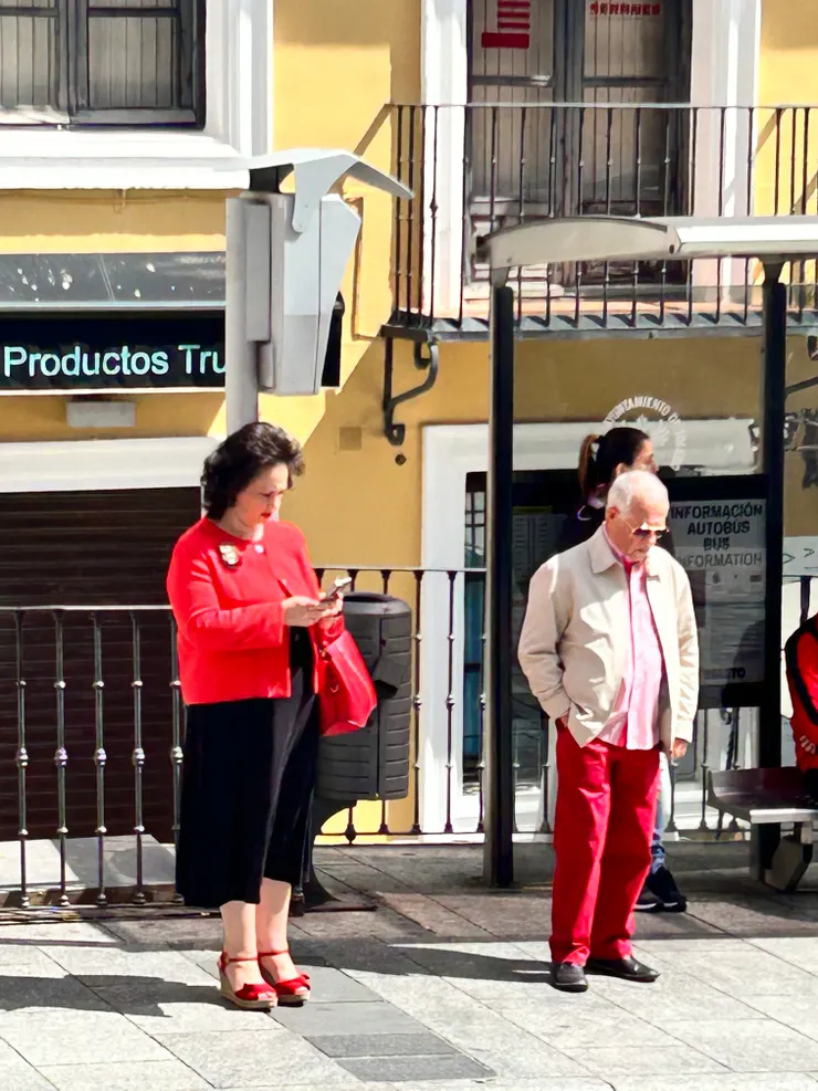 在公車站牌前,不約而同穿紅色卻又搭配各有特色的人。