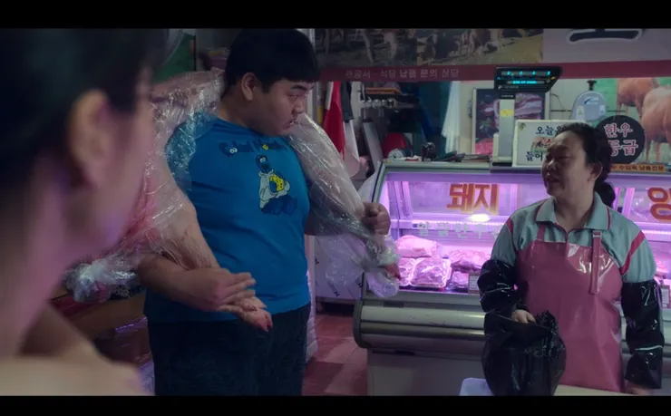 圖中藍衣為肉舖老闆娘疑似障礙的孩子,圖右則為肉舖老闆娘。