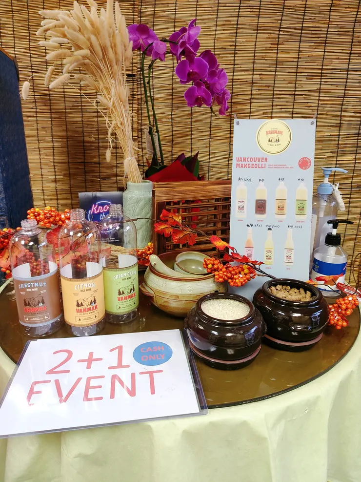 店內櫃檯旁的小桌子，擺放不同口味米酒的空瓶跟促銷活動