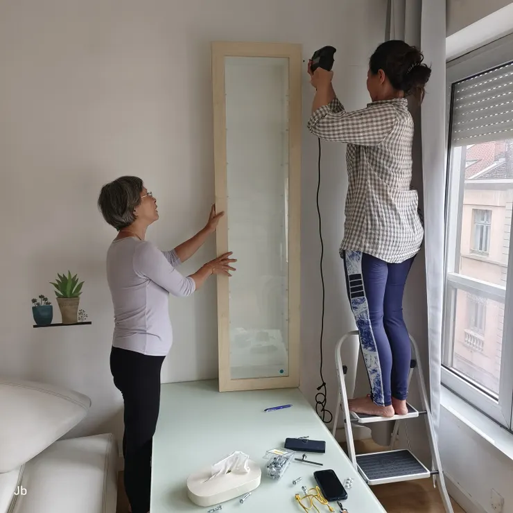 【合力把一座沈重的長方櫥櫃釘上牆！自己做慣了，怡青什麼機司都有，看她正在用電鑽鑽孔。】