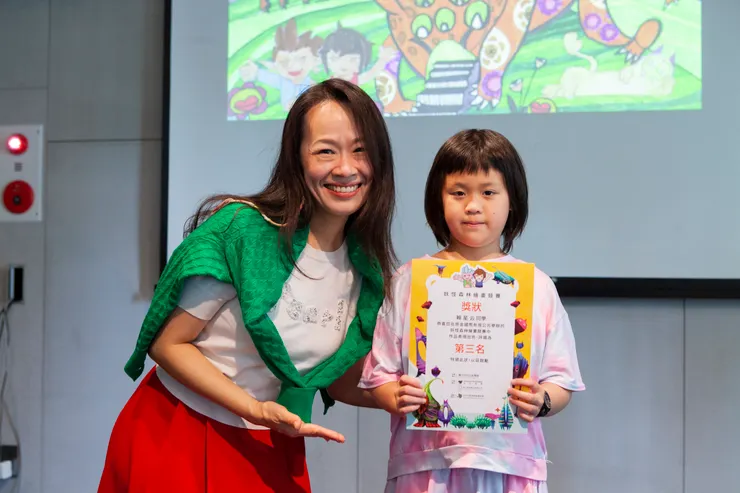 心之谷永續教育園區創辦人文蓓蓓(左)頒發小畫家比賽第三名獎狀, 並與得獎的小畫家合影。