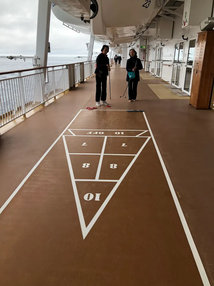 八樓甲板，這不是跳房子，我們隨便玩，規則自己訂。用長棍推鐵盤，看誰的落點分數合計較高。