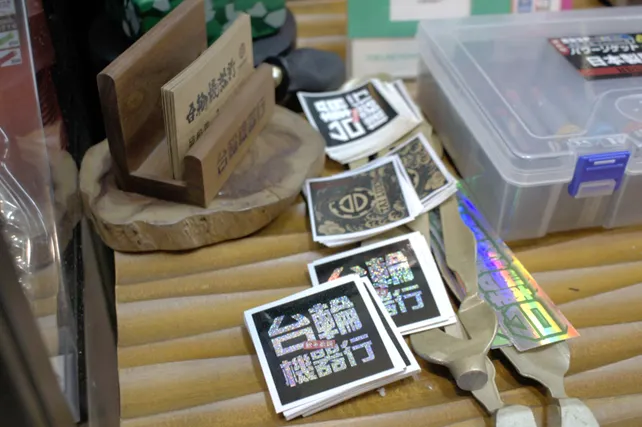 ▲台輪店內的貼紙,底下的零件就是來自三條市的工廠。攝影:呂國維