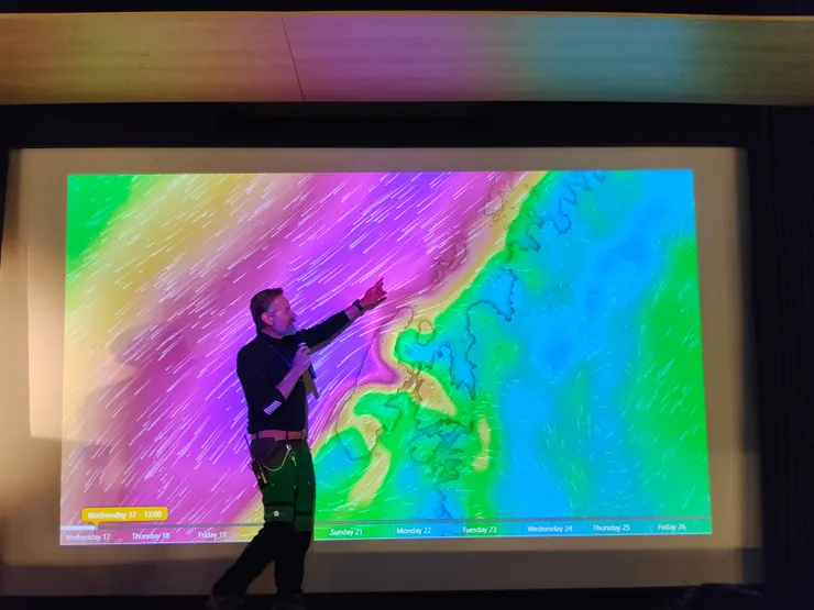 探險隊隊長於演講廳簡報次日天氣狀況及行程。南極。