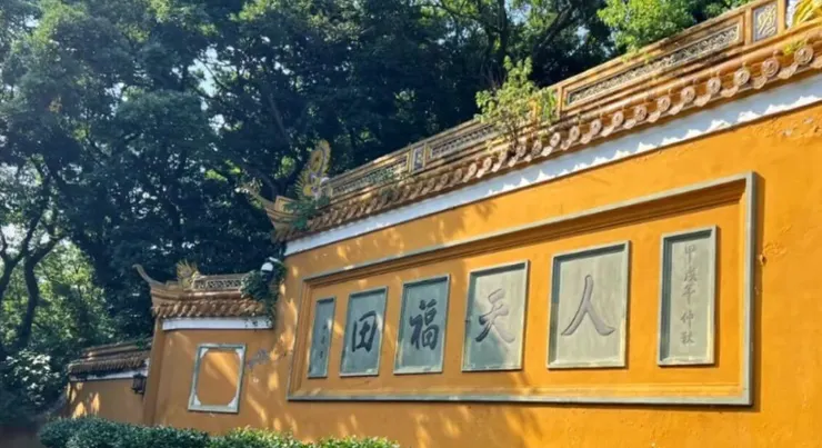 洛迦山牆面上刻著「人天福田」字樣,周圍被翠綠的樹木環繞,顯示出這座寺廟的寧靜氛圍。