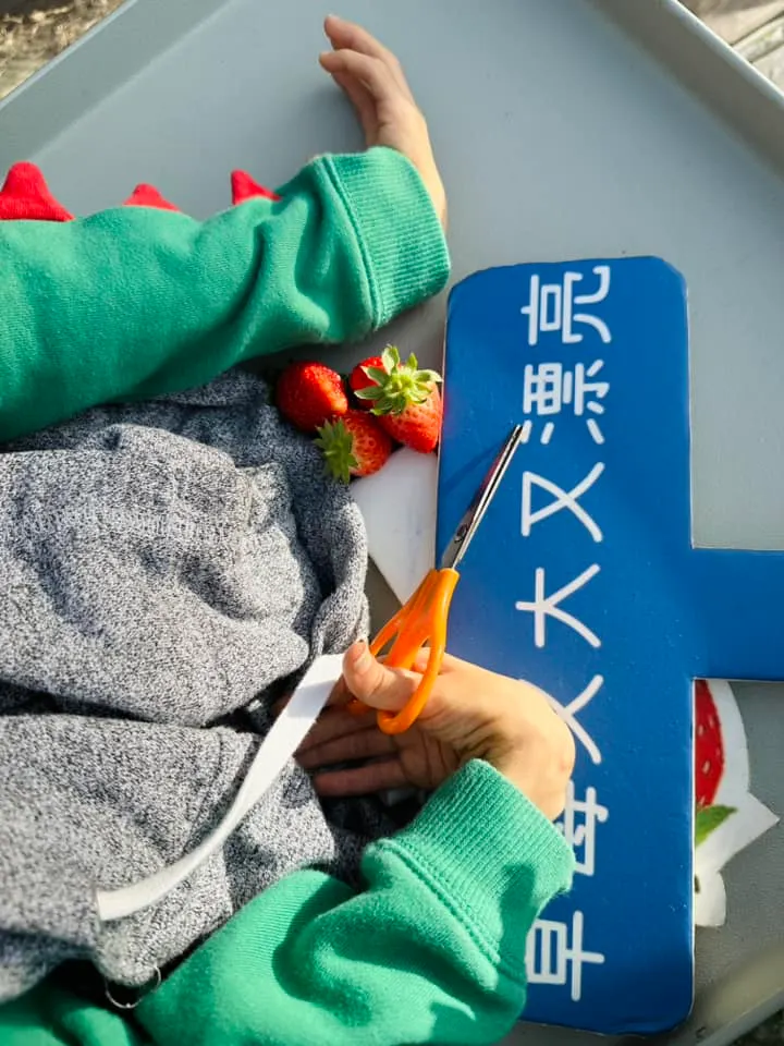 子祐無法自己拿剪刀操作，由我們協助讓他有參與感。
