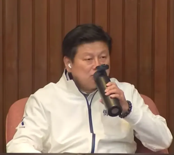 戴著耳機喝東西的傅崐萁