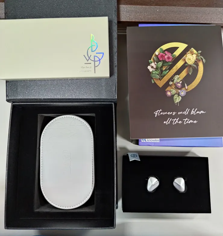 打開來會看到說明書、耳機單體，底下是配件盒和人工皮的收納盒