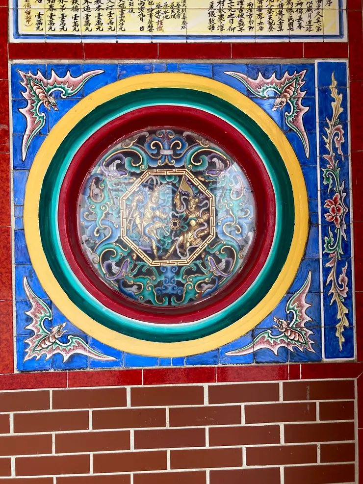 龍邊的圓窗中兩隻螭龍相對，中央還有八角框，框中還有各持兩個寶器的神將兩位。Photo taken by Ching/慶