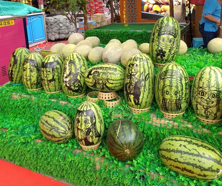 瓜果 新疆有「瓜果之鄉」的美譽，因為日照長、溫差大、水質好、氣候乾燥，特別適合瓜果類作物生長，甜度高、汁多味濃、香氣足，盛產西瓜、哈密瓜、葡萄、紅棗及枸杞等。這攤小販在西瓜上畫圖，特別有趣
