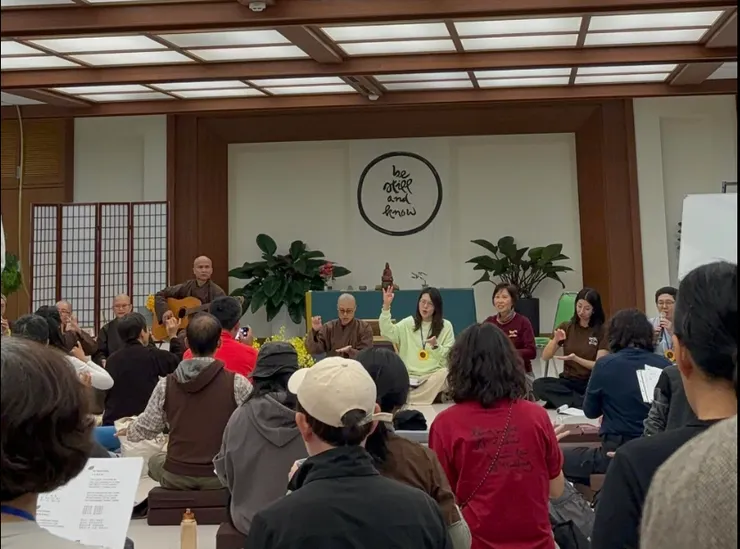 資深法師彈著吉他,年輕法師與志工帶著我們唱歌