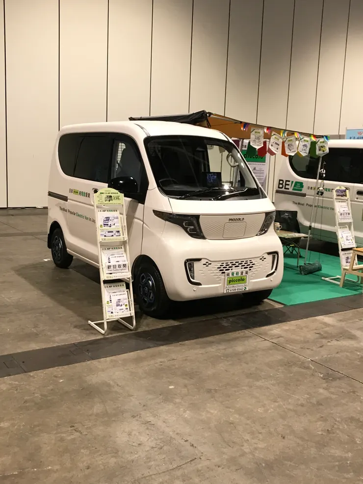 場內有汽車出售，這是輛露營車(有人在旁邊的小桌子很chill地喝咖啡！)。