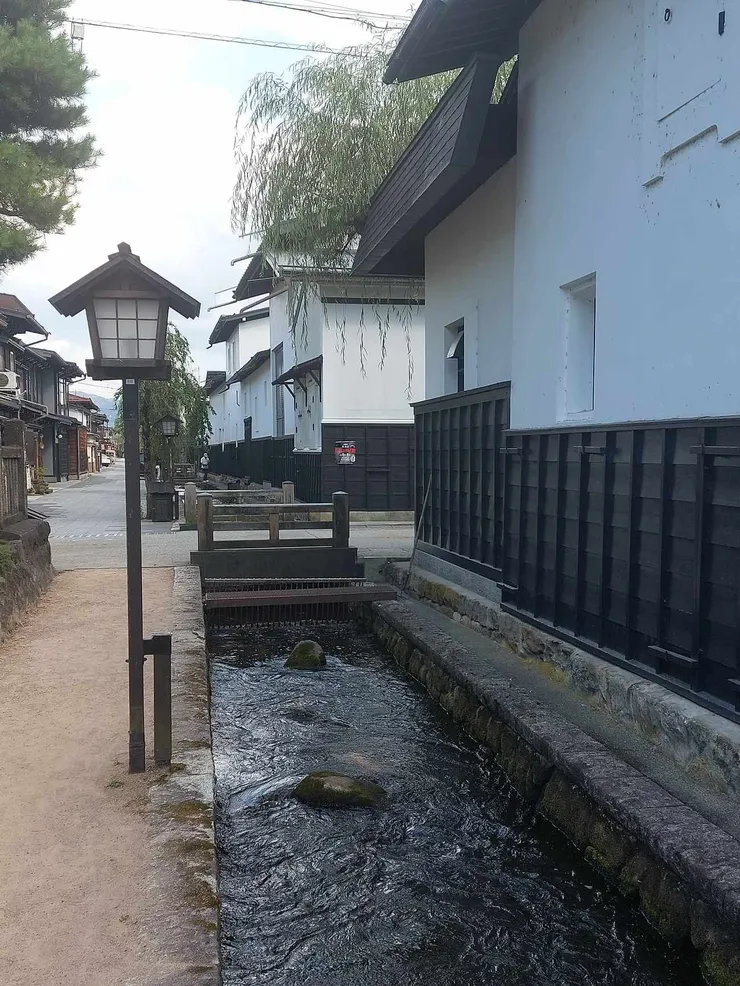 這張圖可以看到我們這邊的道路比較窄，瀨戶川就緊鄰旁邊，往前走後左側行走的道路寬敞許多，旁邊也有一些小店~