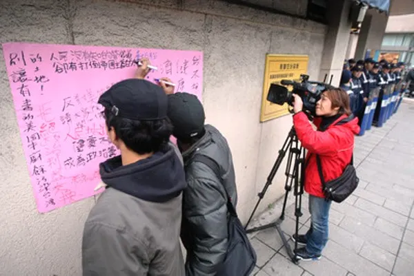 示威者沿途呼喊「反對美牛開放，拒絕出賣健康」的口號。隊伍抵達美國在臺協會（AIT）後，抗議群眾輪流站上肥皂箱表達自己反對美牛的立場，最後，將心中的憤怒寫在美國在臺協會（AIT）的牆上。（圖片：社會主義行動網）