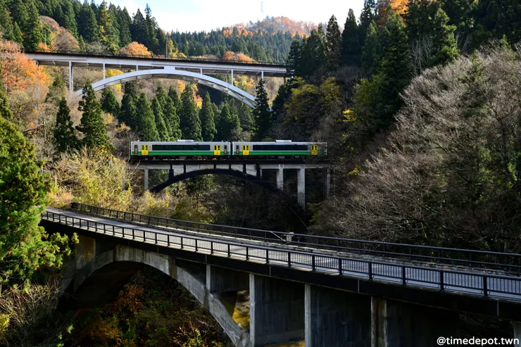 火車在兩座公路拱橋之間穿梭