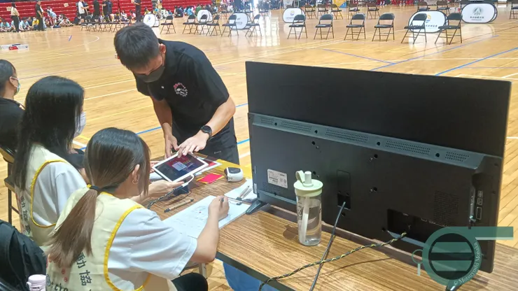 原本讓少主進行記分工作的場次，為了擔綱新手導引者，裁判讓少主指導了兩位記分志工，並在賽程中說明比賽的狀況與應對，此為裁判員在賽前對記分員的叮嚀。