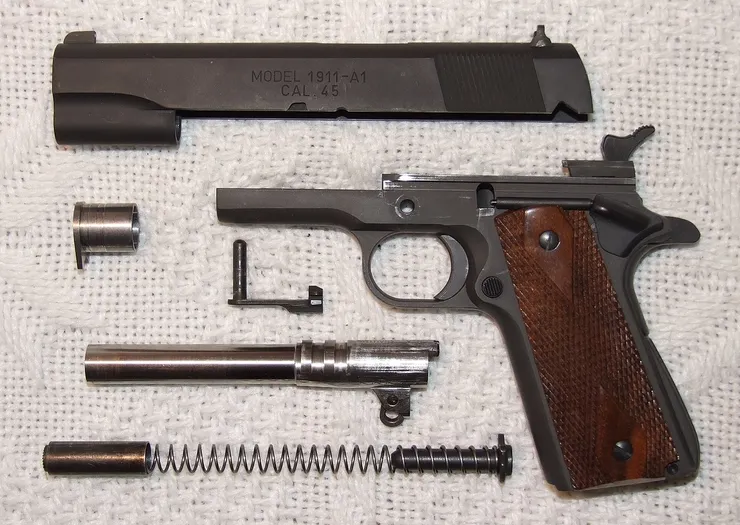 軍用型M1911A1的分解圖片，可見槍管尾端的絞鏈及凸筋。