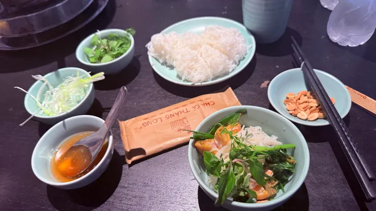 將炒好的魚肉與香草夾入碗中， 搭配米線、花生、魚露或蝦醬。