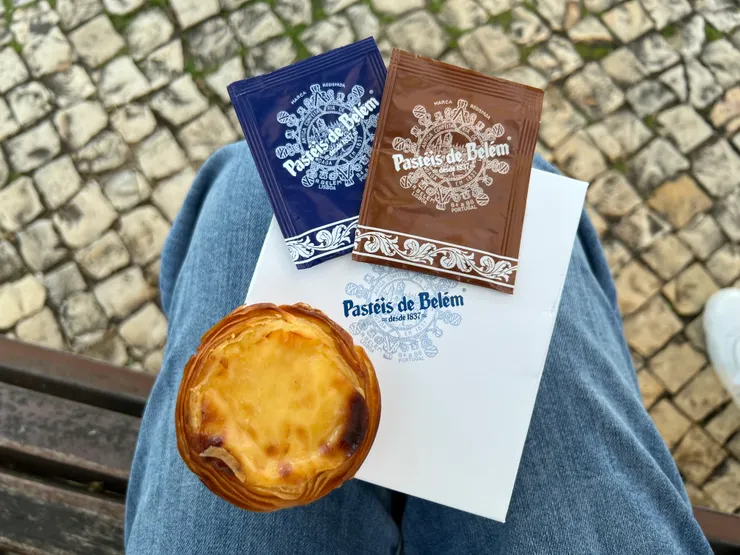 蛋塔和裝著巧克力蛋糕的紙盒,上面藍色包裝為糖粉,棕色包裝為肉桂粉。