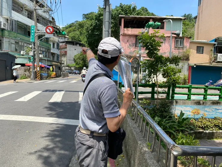 何老師手指萬盛街，昔日瑠公圳圳道，從這裡通往蟾蜍山。而我們就站在萬盛溪與瑠公圳的交會處