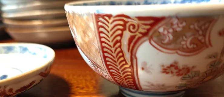 案頭這一整排華美的瓷具，是日本伊萬里燒（有田燒）的經典收藏。從青花染付的清雅，到金襴手的富麗，它們不僅是日常食器，更是一部濃縮的東西文化交融史。