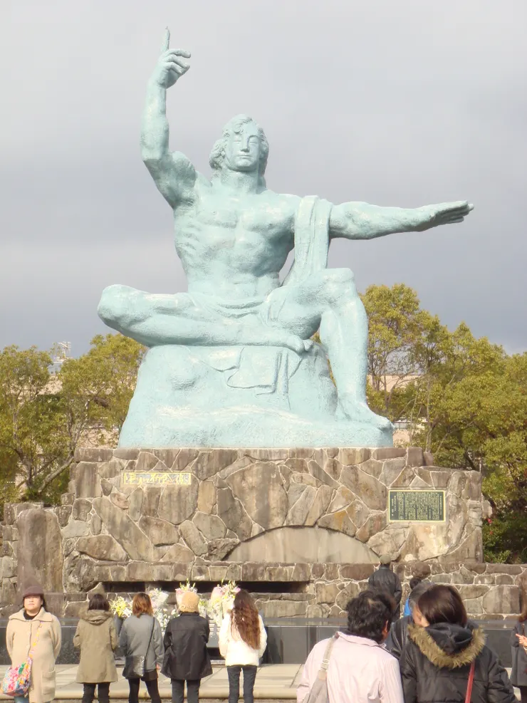 私人拍攝/平和祈念像是北村西望以神的愛與佛的慈悲為象徵，指天右手是象徵原爆威脅，水平伸展左手是象徵和平，輕閉的雙眼是為原爆犧牲者祈福。