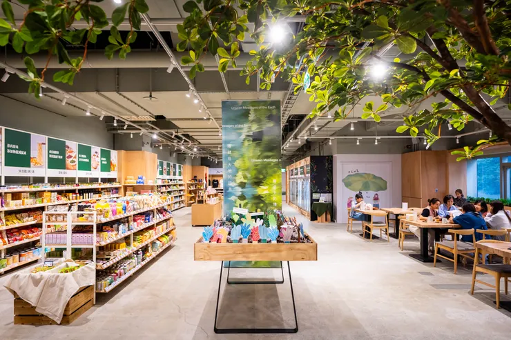 里仁和UOVO Food Design Studio為新門市誠食市集的開幕,聯名推出「餐桌上的博物館」第一波策展「隱藏在大地的訊息」互動展演,引導消費者關注氣候變遷下的食物議題,進而抉擇符合永續概念的食材。策展主視覺掛軸以永續相關的關鍵字,由AI生成的視覺。花園裡的綠葉採用可回收的紙質蜂巢版,大地土壤則以里仁辦公室的文件碎紙和烘烤過的咖啡渣來模擬。