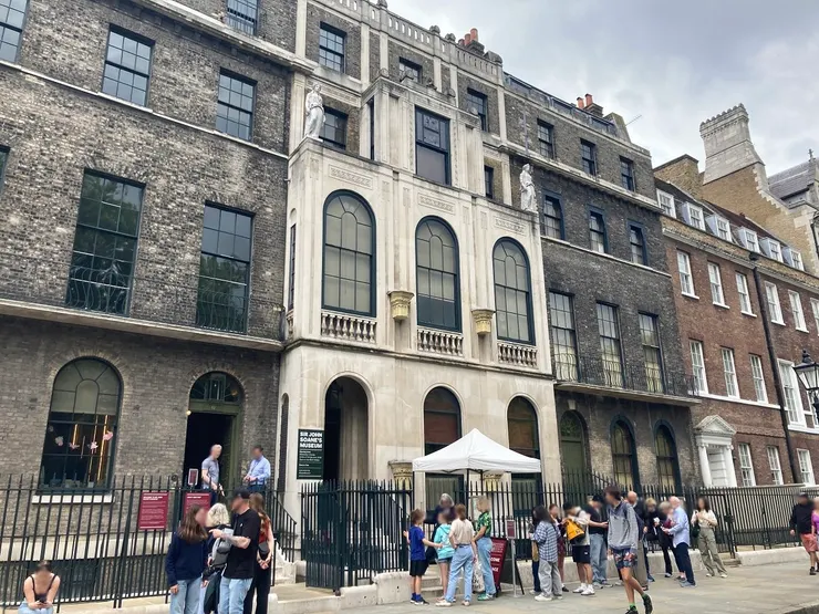 米色外牆的就是博物館正門（13號）入口，旁邊有兩名職員的是出口和行李寄存處（12號）。