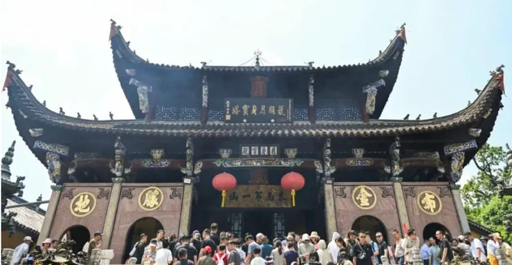 肉身宮的正面建築，雄偉的屋頂裝飾著精美的雕刻和顯眼的紅燈籠，前方擠滿了來訪的遊客，氣氛熱鬧非凡。