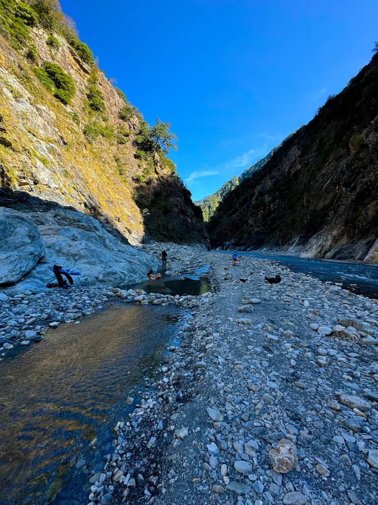 二位台中來的朋友正在最大最舒適的池子泡湯，中間若琪走的地方是營地，右邊是大甲溪