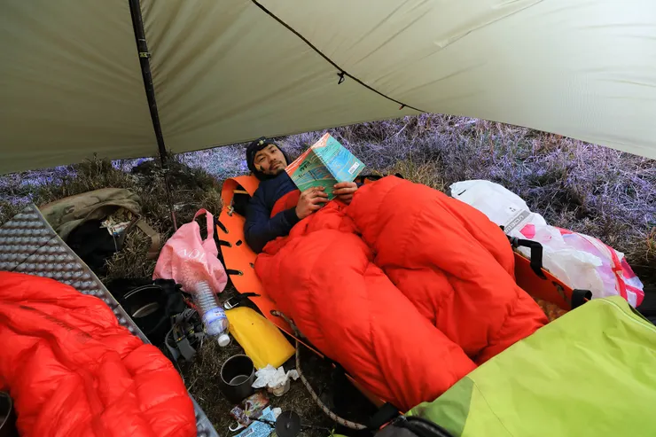 被妥善包覆、吃了止痛藥後，得到片刻放鬆時刻的小曾，正閱讀著《Kulumah．內本鹿：尋根踏水回家路》。