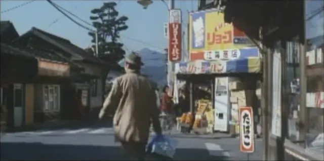 阿寅在老街路口問路後提著禮物離去