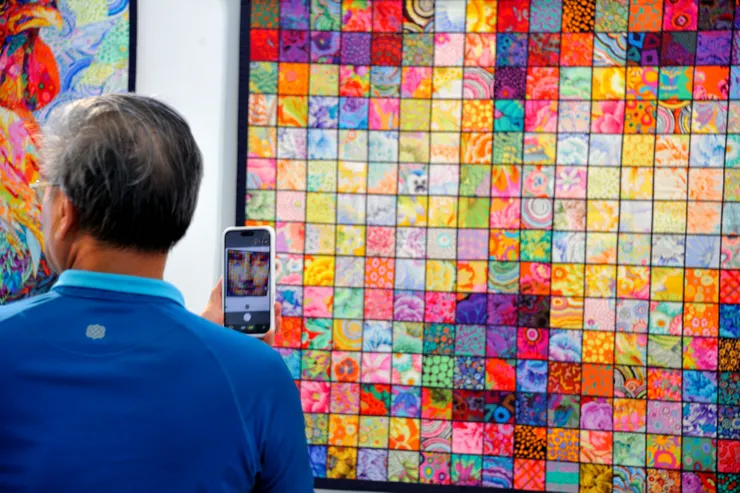 【賞嘆劉棟拚布畫搞怪沙灘夕照中！這幅「蒙娜麗莎」站在畫布前難識廬山真面目，但用手機拍下來就看得很清楚。】