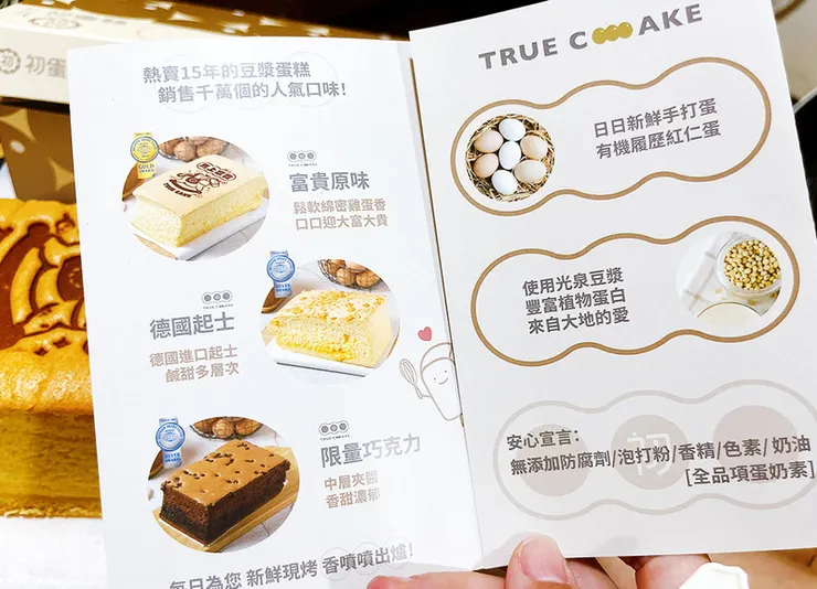 初蛋糕宣傳摺頁內容特寫，介紹富貴原味、德國起士、限量巧克力等口味，並強調使用有機紅仁蛋、光泉豆漿，且無添加防腐劑、泡打粉及色素。