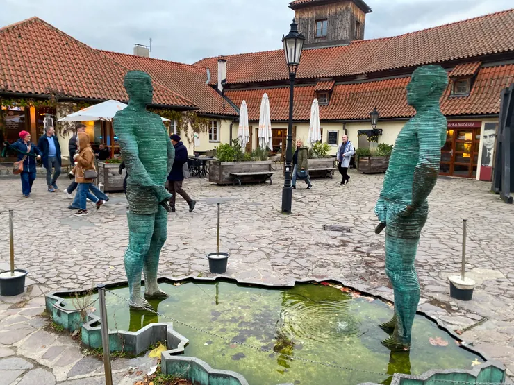 兩個小便的男子(Two Peeing Guys),出自捷克叛逆的藝術家大衛.切爾尼(David Černý,1967~)之手,是其2004年的作品。2名小便的男子機器人,正以緩慢的速動移動,在池水上寫字,這池水輪廓正是捷克的國土形狀。