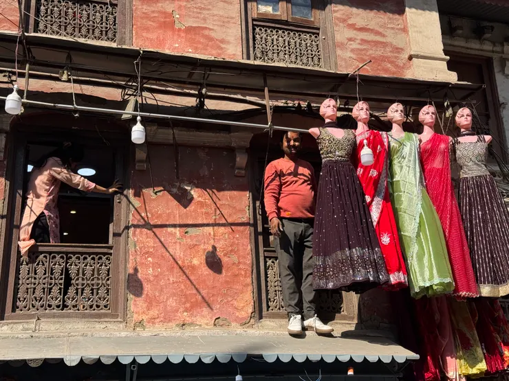 路邊吊掛穿著華服的模特兒，很超現實的畫面！老闆，你每天都要這樣飛簷走壁嗎？